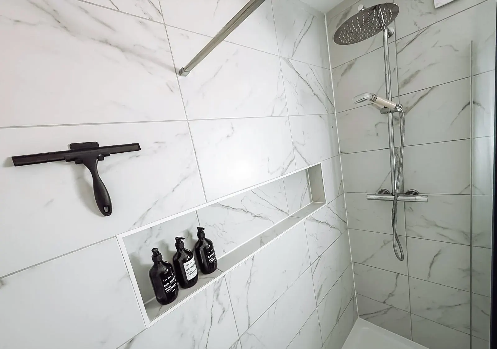 Walk-in shower with rainfall head and tiled shelf