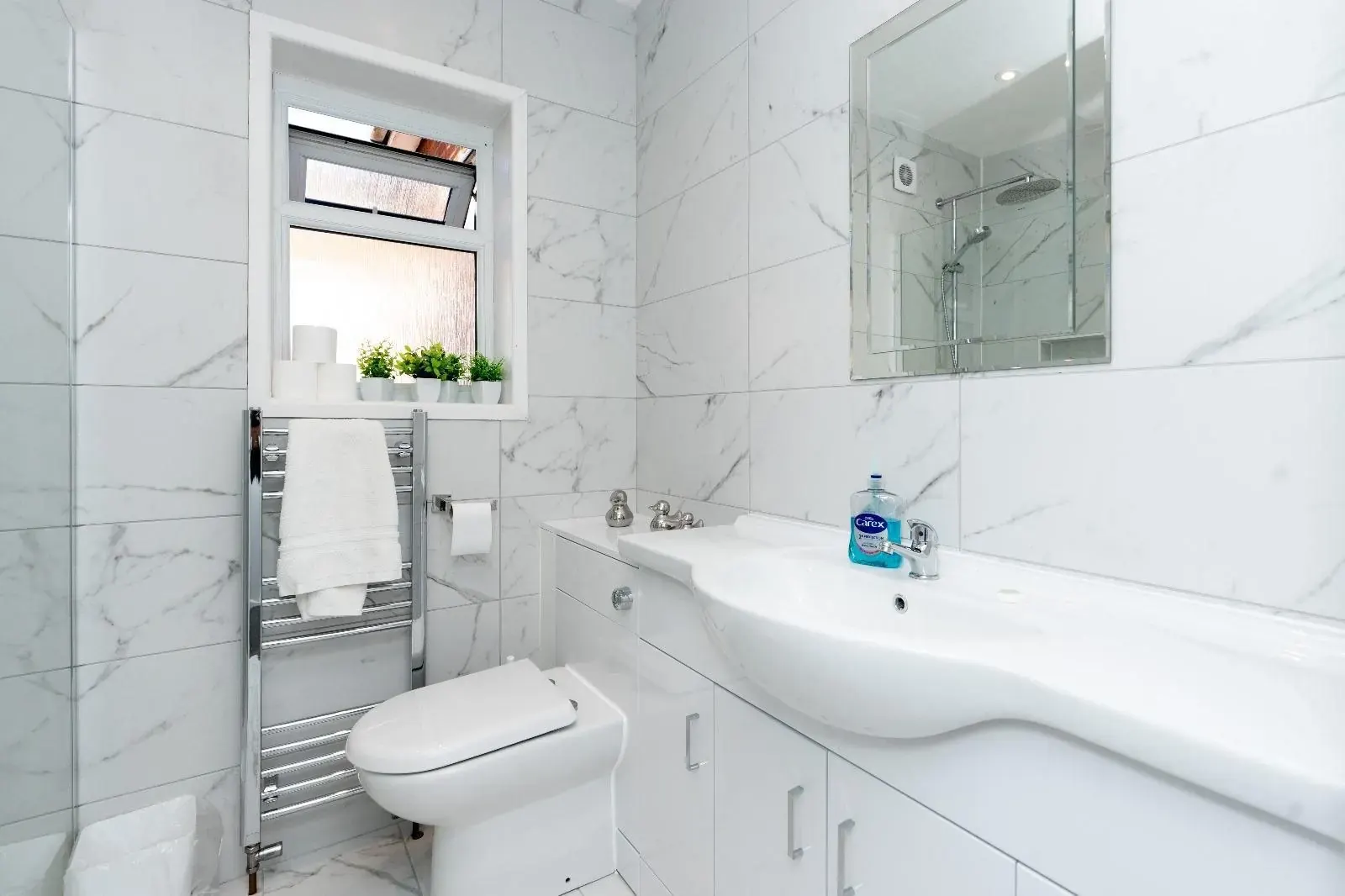 Marble-tiled bathroom with heated towel rail and basin