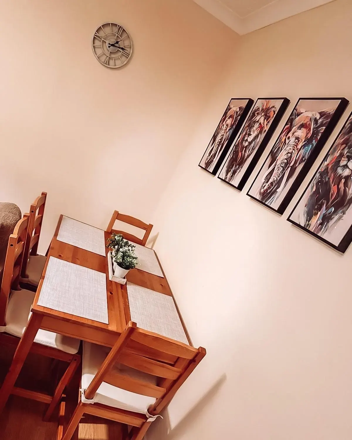 Wooden dining table with place mats and framed animal prints
